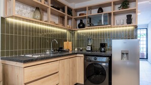A kitchen with wooden cabinets, a built-in oven, a washing machine, and a refrigerator. - Casa Teresa by Barrio México (Guadalajara)