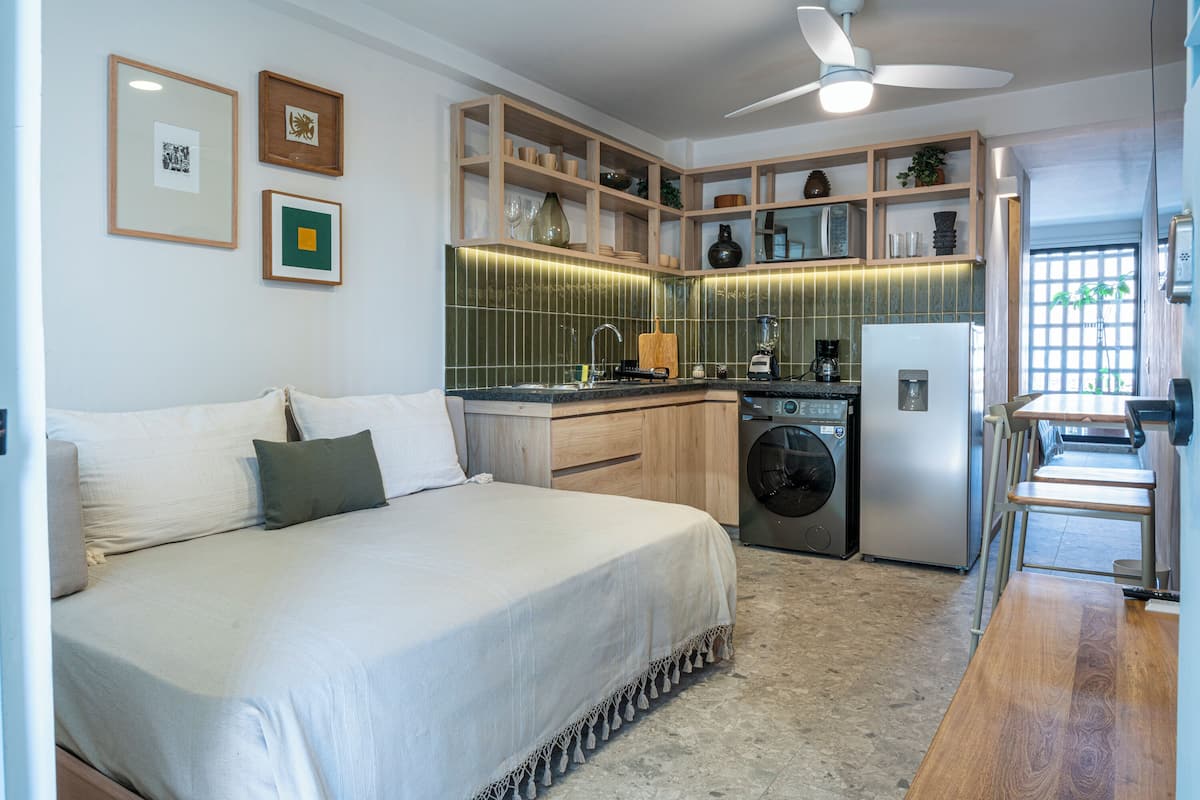 Ein modernes Schlafzimmer mit einem großen Bett, einer Waschmaschine und einem Essbereich mit Tisch und Stühlen.