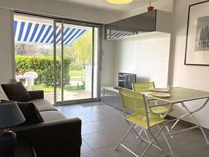 Una cocina moderna con comedor, amplios puertas correderas de cristal a un jardín y un ventilador de techo.