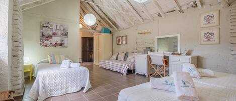 Una habitación con dos camas, un escritorio, una silla y una mesita.