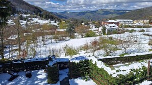 A snow-covered landscape with buildings, trees, and mountains in the background. - Room 'Primula' with Mountain View, Shared Pool and Wi-Fi (Santo Stefano d'Aveto)
