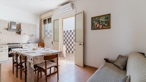 Une cuisine compacte comprenant une table à manger, des chaises et un lit avec des oreillers.