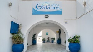 An entrance with a sign reading 'Estudios Galanos,' flanked by large potted plants and an arched doorway. - Apartment 'Studio 6' with Sea View, Wi-Fi and Air Conditioning (Naxos Chora)