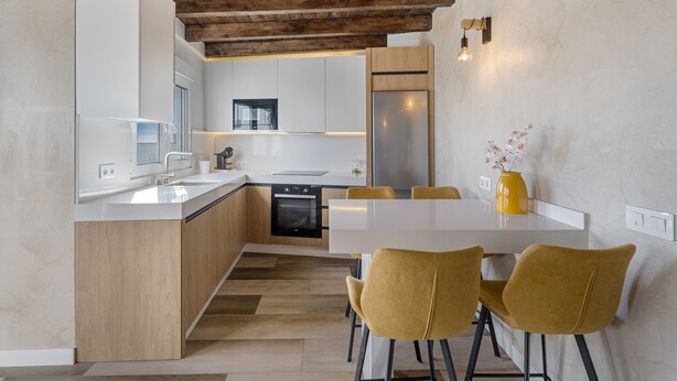 A modern kitchen with a central island, wooden ceiling beams, and a dining area with yellow chairs. - Holiday Home 'Miranda 2' with Sea View, Wi-Fi and Air Conditioning (Igueste de Candelaria)