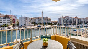 A balcony with a view of a marina, boats, and buildings. - Superb Apartment on Fishermen's Island with Sea View, Private Terrace & Air Conditioning (Agde)
