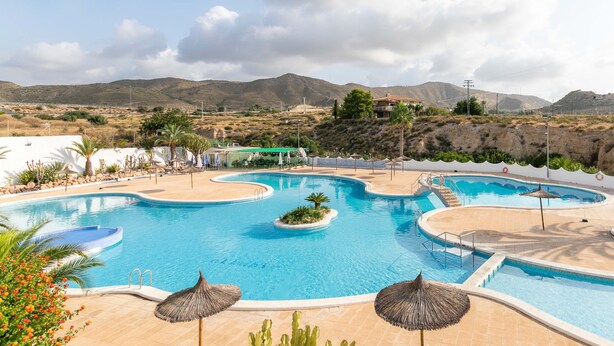 A swimming pool with multiple sections and a surrounding patio area. - Holiday Home 'Spacious' with Shared Pool, Wi-Fi, and Air Conditioning (El Campello)