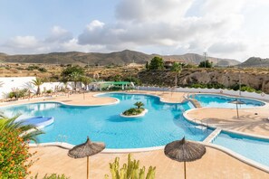 A swimming pool with multiple sections and a surrounding patio area. - Holiday Home 'Spacious' with Shared Pool, Wi-Fi, and Air Conditioning (El Campello)