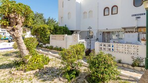 A white building with a street sign 'BLOQUE 62' and a gate with a decorative fence. - Holiday Home 'Spacious' with Shared Pool, Wi-Fi, and Air Conditioning (El Campello)