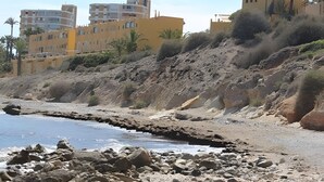 A rocky beach with buildings in the background. - Holiday Home 'Spacious' with Shared Pool, Wi-Fi, and Air Conditioning (El Campello)
