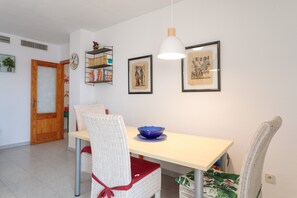 Un comedor con una mesa, sillas, un bol y cuadros en la pared.