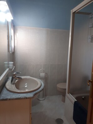 Ein Badezimmer mit Waschbecken, Toilette und Duschbereich.