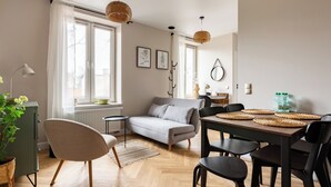 Un salon moderne avec un canapé, une table à manger, des chaises et un radiateur.
