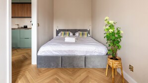 Une chambre à coucher avec un lit, une table de chevet et une plante en pot.