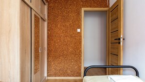 A bedroom with a bed, a wardrobe, and a door.