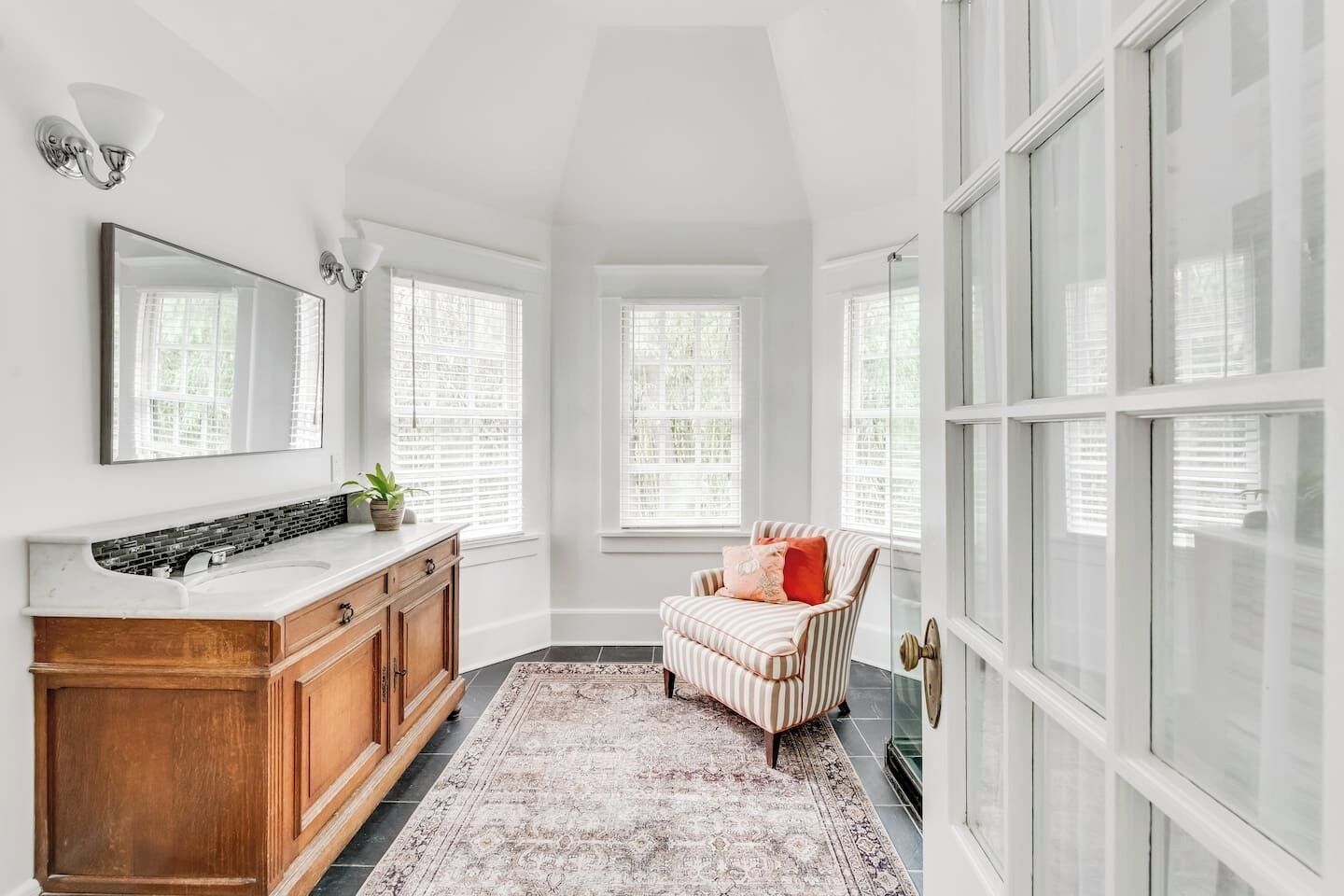 A spacious bathroom with a large vanity, a mirror, and a window.