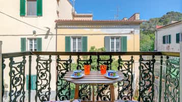 Un balcon avec une table, deux chaises et deux tasses de thé.