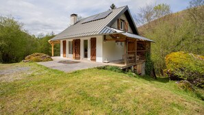 A house with a sloped roof, wooden exterior, and a porch.
