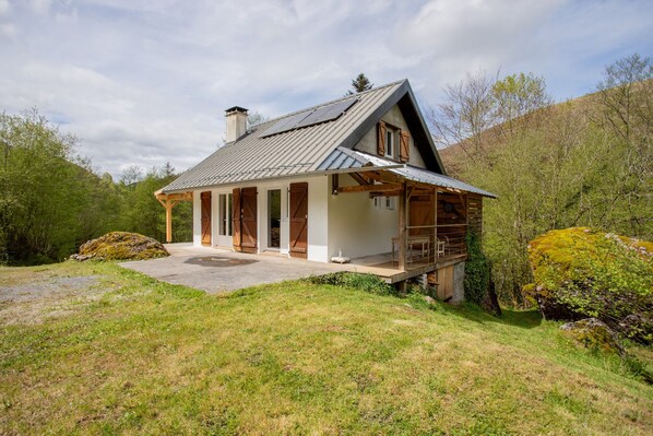 A house with a sloped roof, wooden exterior, and a porch.