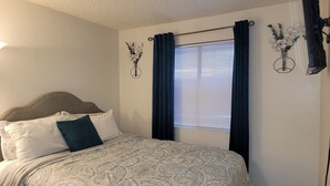 Una camera da letto con un letto, una finestra con persiane e decorazioni a parete.