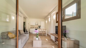 Una sala moderna con sofá, mesa de centro y mueble para televisión.