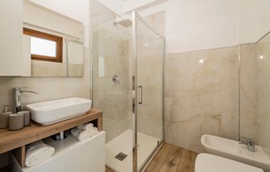A modern bathroom with a glass-enclosed shower, a white sink, and a wooden vanity. - Holiday Apartment "3" with Lake View, Shared Pool & Wi-Fi (Carlazzo)