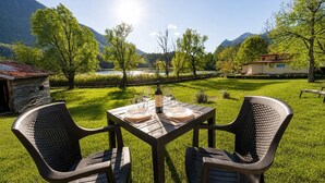 An outdoor dining area with a table set for two, surrounded by chairs, with a scenic view of mountains and a lake in the background. - Holiday Apartment "8" with Lake View, Shared Pool & Wi-Fi (Carlazzo)