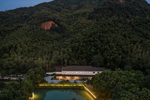 A building surrounded by dense forest and a body of water. - Anji Meilin Resort (Anji)