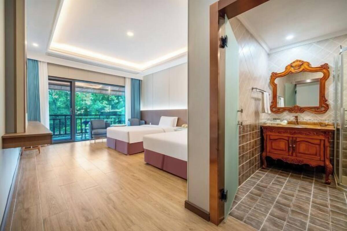 Quarto de hotel com varanda, um espelho grande e um penteadeira de madeira.