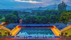 A swimming pool with a view of surrounding buildings and trees. - Anji Meilin Resort (Anji)