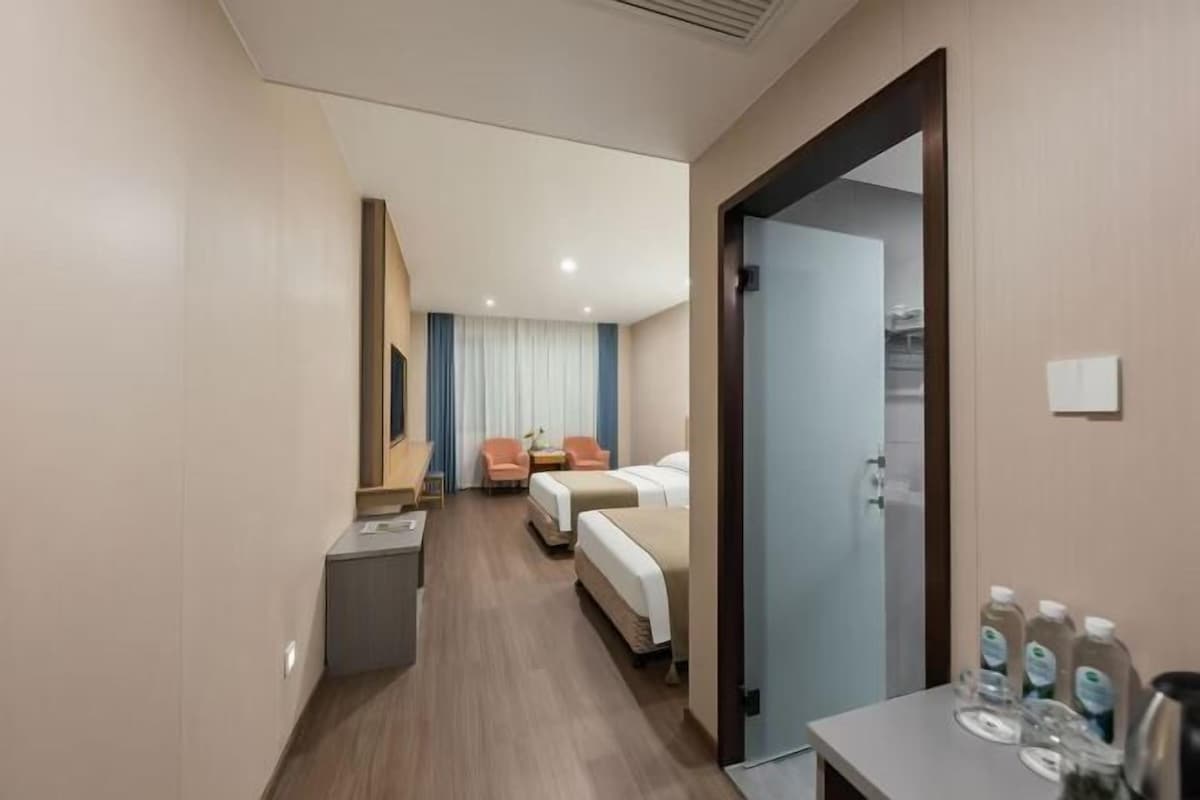 Habitación de hotel con cama, escritorio y silla. Incluye baño con ducha y retrete.
