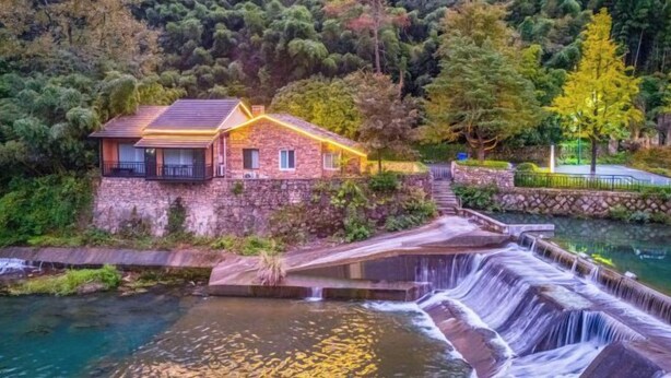 A stone house with a waterfall feature in front. - Anji Meilin Resort (Anji)
