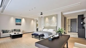 A modern living room with a sofa, a coffee table, a dining table, and a bed with a headboard. - Anji Meilin Resort (Anji)