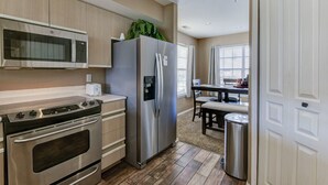 A modern kitchen with stainless steel appliances, a built-in microwave, and a refrigerator.