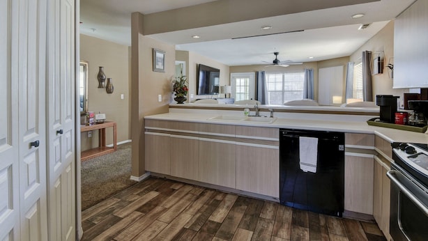 A modern kitchen with a dishwasher, a stove, and a ceiling fan.