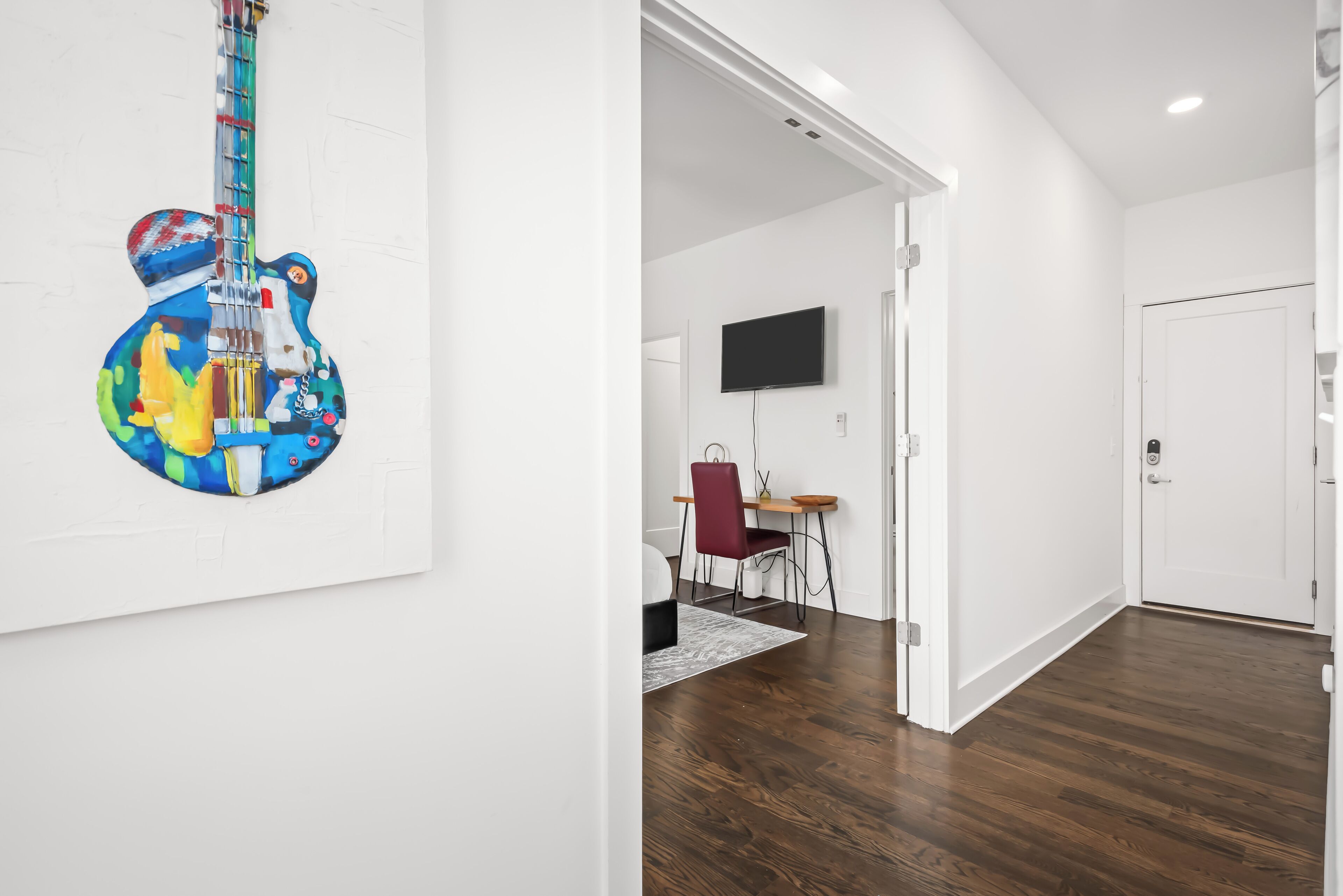 A modern interior with a dining area, a flat-screen TV, and a wooden floor.