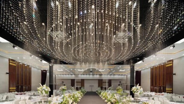 A banquet hall with rows of tables, white chairs, and floral centerpieces. - Neijiang International Hotel (Wanda E-commerce Center) (Neijiang)