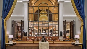 A spacious lobby with a high arched glass window, wooden seating areas, and a central marble table. - Yingde Chocolate Kingdom Hotel (Qingyuan)