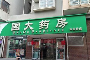 Una fachada comercial con un letrero verde que dice 'GodaDrugstore'.