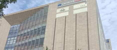 Un edificio de varios pisos con un diseño arquitectónico moderno, que destaca por su fachada de vidrio y señalización que indica que es un centro médico.