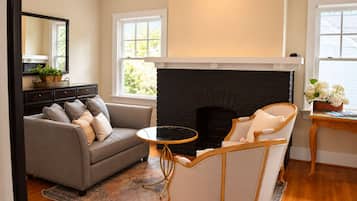 A living room with a fireplace, a sofa, a chair, and a small table.