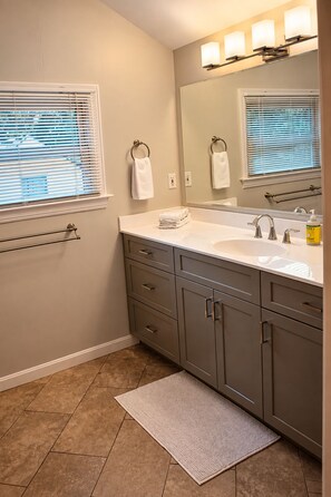 A bathroom with a double sink, vanity, towel rack, and a large mirror. - St. Matthew’s - Walk to Shops & Restaurants (Louisville)