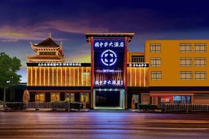 Un hotel con estilo arquitectónico chino tradicional, un edificio moderno y una entrada bien iluminada.