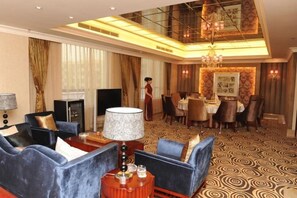 A hotel room with a seating area, a dining setup, and a chandelier. - Yuanzhongfang Hotel (Pingdu)