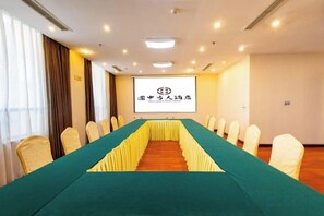 A conference room with a long table, chairs, a projector screen, and a presentation on the screen. - Yuanzhongfang Hotel (Pingdu)