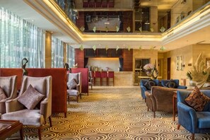 A hotel lobby with a check-in desk, seating area, and a patterned carpet. - Yuanzhongfang Hotel (Pingdu)