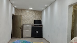 A bedroom with a bed, a wardrobe, and a small cabinet. - Rancho Dos Anjos Farm in Campinas - Daily Rates, Seasons and Events (Campinas)