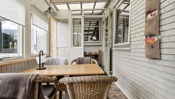 A cozy room with a wooden table and wicker chairs, a window with a view, and a wall-mounted sign. - Beautiful home in Aabenraa with WiFi (Aabenraa)