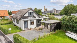A modern two-story house with a balcony, a small garden, and a gravel driveway. - Beautiful home in Aabenraa with WiFi (Aabenraa)