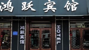 A hotel with a sign that reads "HOTEL" and another sign that says "鸿跃宾馆". - Huma Hongyue Hotel (Huma)