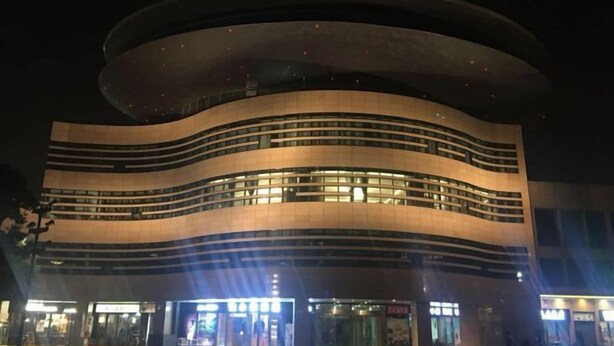 Een modern gebouw met een gebogen gevel en meerdere lagen ramen.